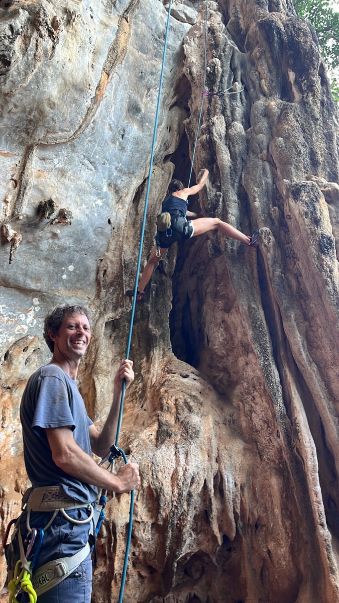 A guide belaying a climber on limestone at Railay