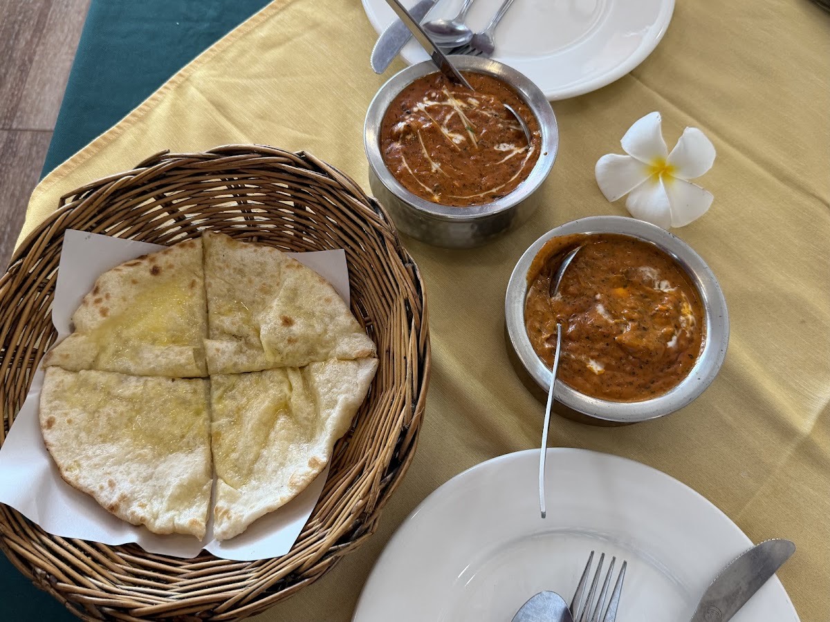 Garlic naan in a basket with two curries at Kohinoor