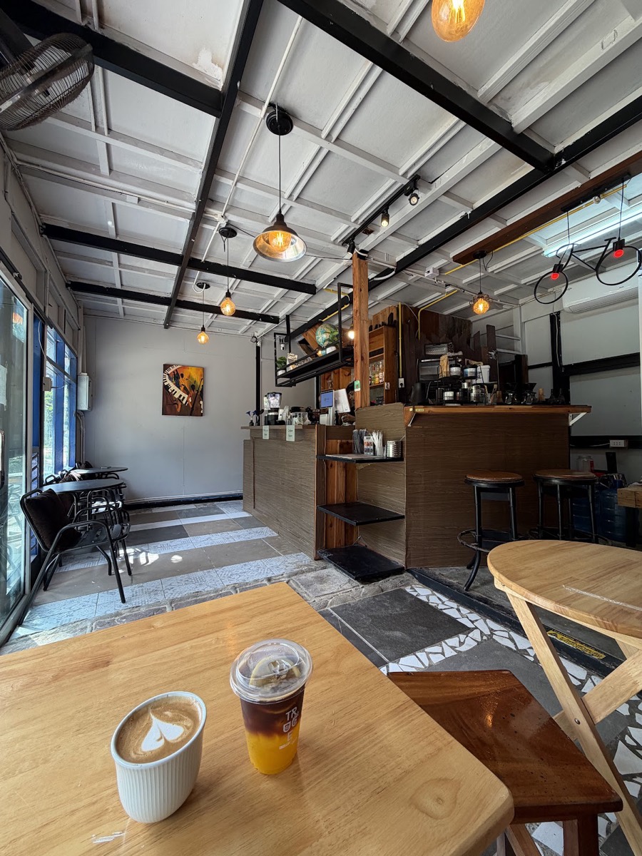 Interior of Truce Coffee — a narrow room with wooden tables, a bar and an air-conditioning unit